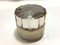 Front view of the container showing brand logo on lid and text on jar.