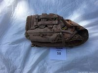 Front view of brown leather Cooper baseball glove showing laces and Coop logo patch on back of glove.