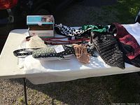 Overview of the lot showing puppy carrier, leashes, collars, toys and pet clothing items displayed on table.