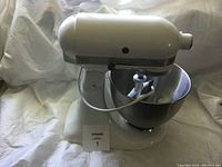 Front view of white mixer with bowl and paddle installed