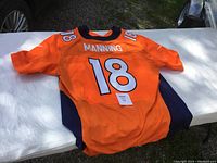 Back view of the orange Peyton Manning #18 Denver Broncos NFL jersey showing the name and number details clearly.