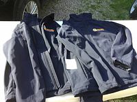 Two dark navy blue jackets with NAPA Auto Parts embroidered logos on the left chest, laid flat showing front and side views.