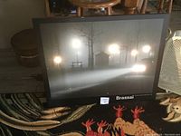 Picture showing the framed foggy street scene with street lamps glowing and car headlights illuminating the fog.