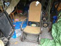 Full view of the vintage wicker and wood rocking chair showing the full backrest, seat and rockers.