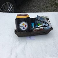 Basket with Steelers Scentsy wax warmer, wax scents, power cord, and fan accessory on white tablecloth