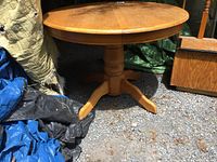 Photo of the full round pine pedestal kitchen table outdoors, showing the table base and leg style.