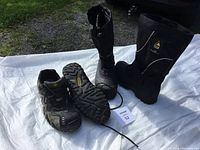 Pair of Terra steel toe work shoe and black Thinsulate insulated work boots displayed on white cloth outdoors