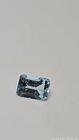 Clear close-up of natural sky blue topaz gemstone with emerald cut.