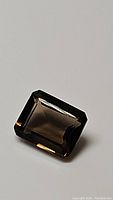 Close-up of a single emerald cut smokey quartz gemstone with brown smoky color and high clarity.