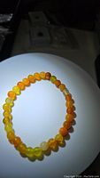 Full view of the yellow agate bracelet laid flat, showing its color and bead shape under lighting.