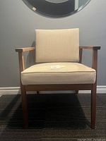 Front view of walnut armchair showing full frame and upholstery