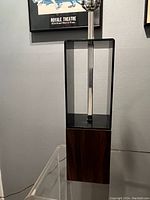 Full view of the lamp showing the smoked lucite rectangular section and the faux rosewood base with aluminum rod and socket.