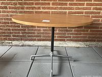 Full front view of round table showing top, support column and four-star base