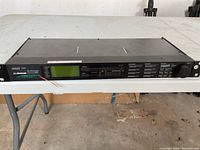 Front view of t.c. electronic mastering processor showing control buttons, display screen, and power button.