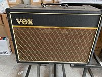 Front view of amplifier showing black Tolex exterior, brown diamond grill cloth and gold Vox logo