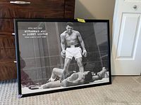Full view of the framed Muhammad Ali vs Sonny Liston boxing print showing the black and white image and text.
