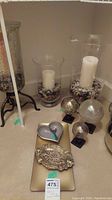 Photo showing the full assortment of items: 3 glass orbs on pedestals, 3 white pillar candles in glass holders with stones, a rectangular glass tray, metal ash tray, heart tray and spoon on floor