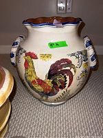 Frontal view of largest planter showing colorful rooster image, handles, and rim details