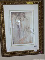 Front view of signed and numbered silhouette print under glass with ornate frame, showing numbering at top and label at bottom right.