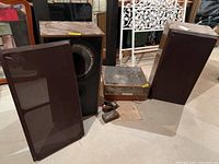 Record player, two floor speakers, instruction manual, and disc cleaner brush arranged on concrete floor