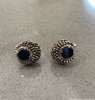 Front view of gold washed sterling silver cuff links with black onyx stone center, showing beaded detail.