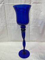 Full front view of the cobalt blue candle holder showing flared cup, twisted stem and round base