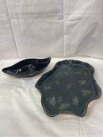 Organic-shaped tray with leaf motifs seen from top, next to planter