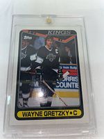 Front side of 1990 Topps Wayne Gretzky hockey card showing player in Los Angeles Kings uniform with protective case.