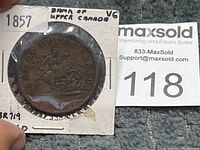 Obverse side of the 1857 Bank of Upper Canada one penny token coin in a protective holder with labeling.