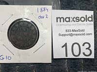 Close-up photo of the Canadian penny from 1884 in a 2x2 card holder showing the reverse side with 'ONE CENT' and the year '1884' in a circular wreath design. The grade marked on the card is G10 and reverse type is noted as Reverse 2.