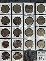 Top down view of 18 Canadian dollar coins arranged in four rows, loose in plastic coin flips with handwritten years from 1968 to 1986.