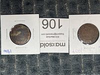 Both Canadian pennies from 1906 and 1909 visible in cardboard holders, laid side by side.