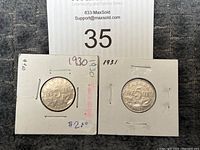 Two Canadian 5 cent coins dated 1930 and 1931, each in a protective cardboard coin holder with handwritten dates and price.