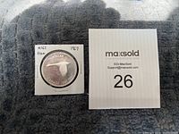 Photo of the coin in a holder showing the flying goose and inscriptions "DOLLAR CANADA 1867-1967."