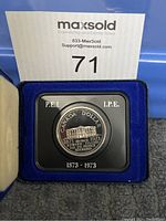Closed view of 1973 Canada PEI Centennial dollar coin in blue velvet presentation case with MaxSold lot number