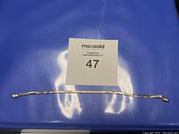 Full length flat view of bracelet on blue background