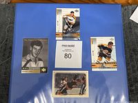 Four Bobby Orr hockey cards arranged on blue background showing front faces including NHL Legends and Upper Deck Masterpieces series.