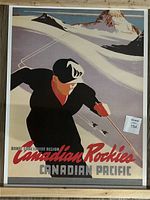 Framed poster showing a skier descending snowy mountain with Canadian Rockies background and promotional text for Canadian Pacific Ski Region.