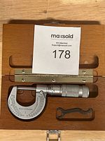 Top view of Brown & Sharpe micrometer placed inside a wooden case accompanied by a small wrench