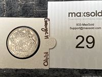 Photo showing front design of the silver Canadian 50 cent coin from 1940 with coat of arms and inscriptions.