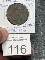 Front view of 1812 Tiffin penny token coin showing seated figure and date.