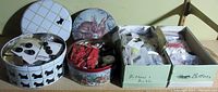 Two decorative round tins and two boxes filled with various buttons and crafting items from an overhead view.