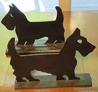 Pair of cast iron Scottie dog boot scrapers on wooden table