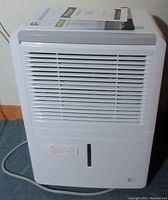 Front view of white Perfect Aire dehumidifier with air vent grille and water window, power cord visible.