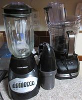 Black and Decker blender with glass container and Hamilton Beach food processor side by side on counter with a small black/silver appliance in front