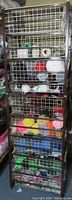 Full height view of the metal stand with wire drawers filled with yarn, showing a variety of colors and skein sizes clearly.
