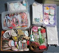 Photo showing multiple plastic containers filled with various types of ribbon, lace, and trim