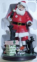 Front view of Santa's Little Scotties figurine, showing Santa in red suit, three black Scottie dogs, wrapped gift, and Santa's toy sack on base.