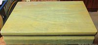 Closed wooden box with greenish wood grain finish