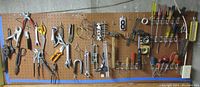 Wide view of the pegboard displaying the miscellaneous set of tools including screwdrivers, pliers, hammers, and tape measure.